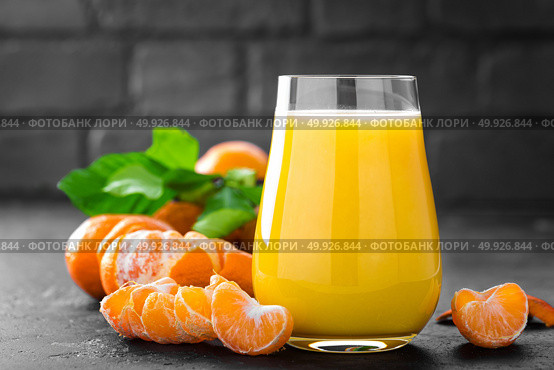 Tangerines, peeled tangerines and tangerine juice in glass. Mandarine juice and fresh fruits with leaves. Стоковое фото, агентство Ingram Publishing / Фотобанк Лори