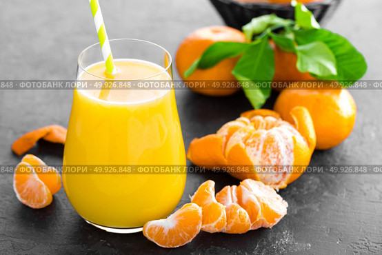 Tangerines, peeled tangerines and tangerine juice in glass. Mandarine juice and fresh fruits with leaves. Стоковое фото, агентство Ingram Publishing / Фотобанк Лори