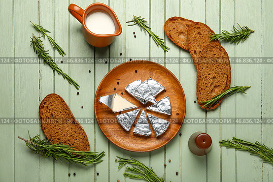 Тарелка с треугольниками вкусного плавленого сыра и хлебом на зеленом деревянном фоне. Стоковое фото, фотограф Pixel_shot / Фотобанк Лори