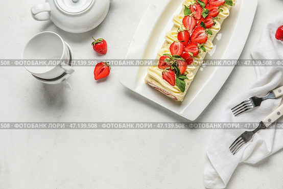 Тарелка с вкусным клубничным рулетом и чайным сервизом на светлом фоне. Стоковое фото, фотограф Pixel_shot / Фотобанк Лори