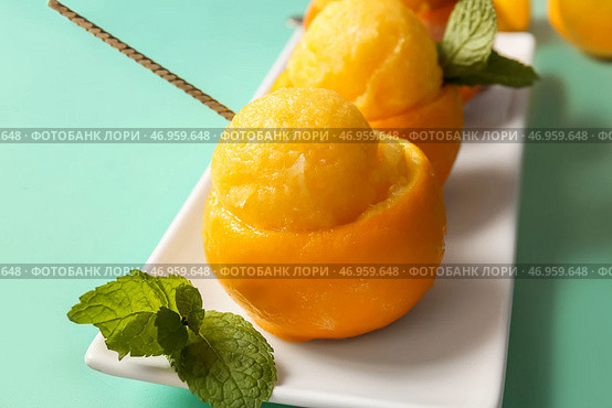 Тарелка с вкусным мороженым в апельсиновых корках на цветном фоне. Стоковое фото, фотограф Pixel_shot / Фотобанк Лори