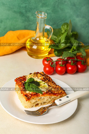 Тарелка вкусного итальянского пирога с моцареллой и соусом песто на столе. Стоковое фото, фотограф Pixel_shot / Фотобанк Лори
