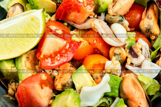 Tasty salad with mix of vegetables, seafood and fresh green lettuce. Macro.. Homemade seafood salad with fish mussels, octopus. Стоковое фото, агентство Ingram Publishing / Фотобанк Лори