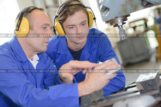 teacher showing student how to operate machine. Стоковое фото, агентство Ingram Publishing / Фотобанк Лори