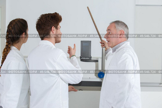 team standing grouped in front of white board. Стоковое фото, агентство Ingram Publishing / Фотобанк Лори