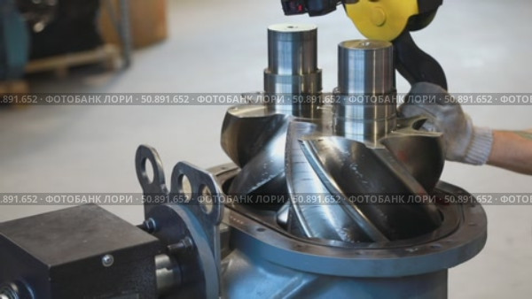 Technician assembling rotor of industrial screw compressor. Стоковое видео, видеограф Юрий Поздников / Фотобанк Лори