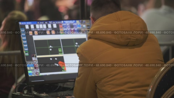 Technician operating computer to manage stage lighting system during event setup. Стоковое видео, видеограф Антон Гвоздиков / Фотобанк Лори