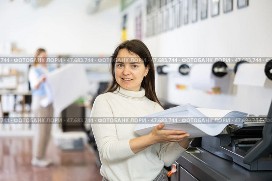 Technician operator changes paper on printer plotter machine. Стоковое фото, фотограф Яков Филимонов / Фотобанк Лори