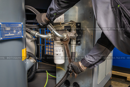 Technician repairing industrial compressor using a wrench. Стоковое фото, фотограф Юрий Поздников / Фотобанк Лори