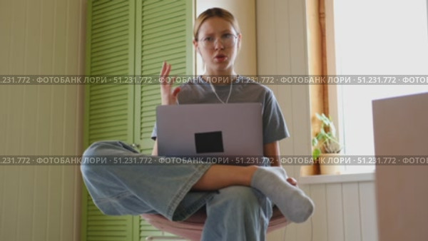 Teen girl school student wear headphones watching online webinar, talking through webcam looking at laptop. Teenager conducting video conference on computer at home, chatting online with friends. 4K. Стоковое видео, видеограф Марина Демидюк / Фотобанк Лори