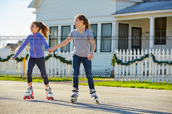 Teen girls group rolling skate in the street outdoor. Стоковое фото, агентство Ingram Publishing / Фотобанк Лори