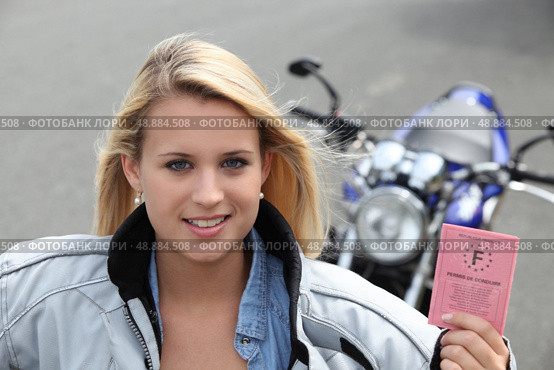 Teenage girl with motorbike and driving licence. Стоковое фото, агентство Ingram Publishing / Фотобанк Лори