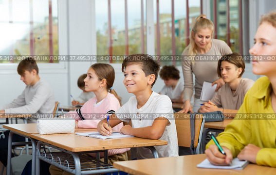 Teenagers sitting at desks in classroom during lesson. Стоковое фото, фотограф Яков Филимонов / Фотобанк Лори