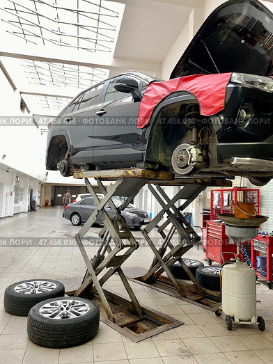 Техническое обслуживание автомобиля в мастерской, проверка ходовой части автомобиля на подъемнике (2023 год). Редакционное фото, фотограф Светлана Акифьева / Фотобанк Лори
