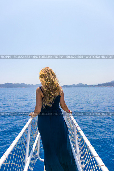 Tekirova, Turkey - June 14, 2025: woman stands on the bow of a yacht and looks into the distance. Стоковое фото, фотограф Анастасия Мерчик / Фотобанк Лори