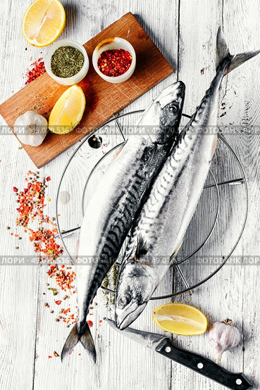Thawed fresh fish mackerel with spices and marinade with lemon.Photograph high key.Top view. Carcasses frozen mackerel. Стоковое фото, агентство Ingram Publishing / Фотобанк Лори