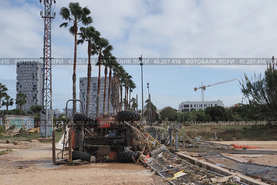 The aftermath of hurricane Dana in Valencia, Spain - Devastating consequences of flooding in Valencia, overturned tractor and debris. Стоковое фото, фотограф Данил Руденко / Фотобанк Лори