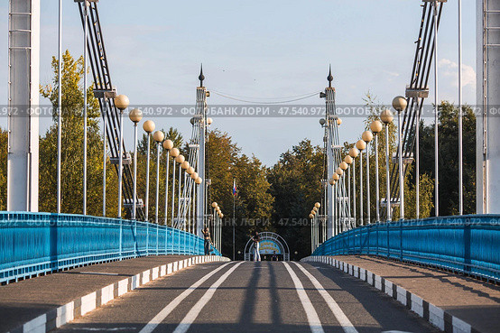 The bridge over the Kotorosl River to Damansky Island and people passing by. Yaroslavl, Russia. Редакционное фото, фотограф Photojuli / Фотобанк Лори