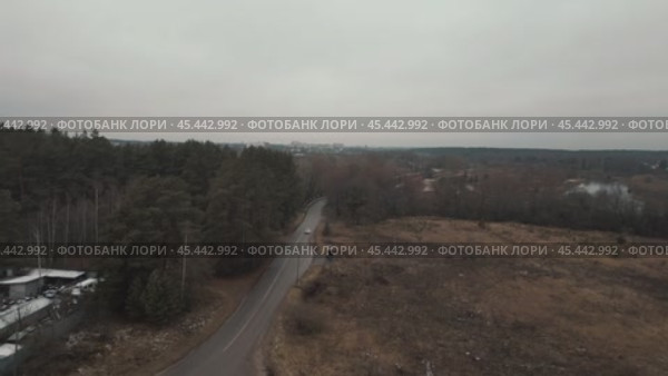 The camera flies under the gloomy autumn sky along the bell towers of the rural white temple and flies out onto the road. Стоковое видео, видеограф Ярославский Максим / Фотобанк Лори
