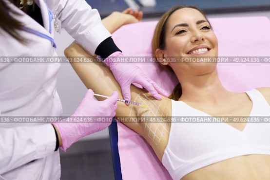 The doctor makes intramuscular injections of botulinum toxin in the underarm area against hyperhidrosis. Cosmetology skin care. Doctor makes intramuscular injections of botulinum toxin in the underarm area against hyperhidrosis. Стоковое фото, агентство Ingram Publishing / Фотобанк Лори