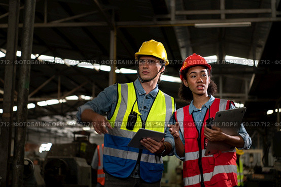 The foreign chief engineer came to inspect the old mechanical factory. There is an African female mechanic explaining details and progress reports on old machines being repaired to restore normal operation. Стоковое фото, агентство Ingram Publishing / Фотобанк Лори