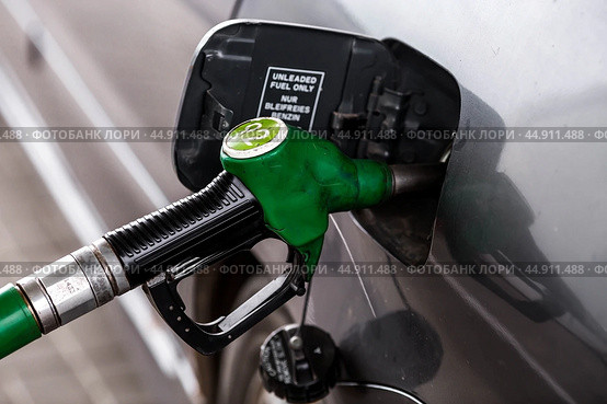 The gas station. Filling the car with gasoline. A Russian fuel dispenser in the fuel tank of a car at a gas station. Rising fuel prices around the world. Стоковое фото, фотограф Photojuli / Фотобанк Лори