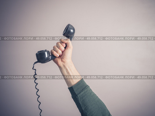 The hand of a young man is holding a vintage rotary telephone. Стоковое фото, агентство Ingram Publishing / Фотобанк Лори