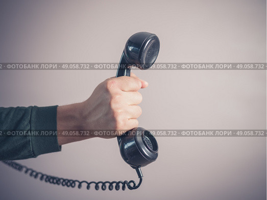 The hand of a young man is holding a vintage rotary telephone. Стоковое фото, агентство Ingram Publishing / Фотобанк Лори