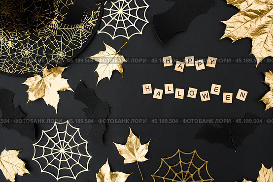 The inscription happy Halloween. Modern background with black bats, Golden leaves, cobwebs and wooden letters. Halloween with copy space for text. Flat lay, top. Стоковое фото, фотограф Photojuli / Фотобанк Лори
