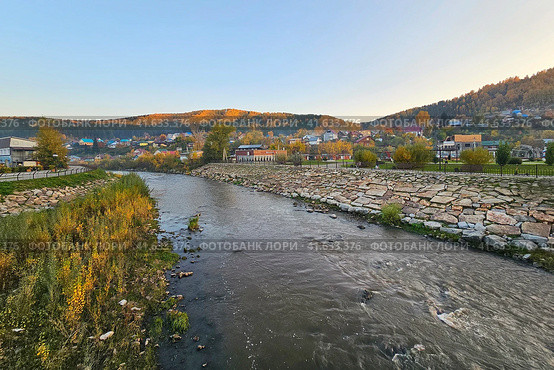 The Mayma River. Evening village on the banks of a mountain river. Rustic landscape.  Rocky bed of the river flowing through the village. Gorno-Altaisk. Стоковое фото, фотограф Саблин Станислав / Фотобанк Лори