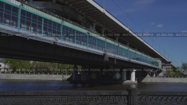 The Moscow metro train arrives at Vorobyovy Gory station on the metro bridge. It's a sunny day. Russia. Moscow 01.05.2024. Редакционное видео, видеограф Ярославский Максим / Фотобанк Лори