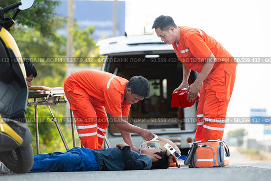 The paramedic  is assisting an injured man in an emergency situation on the road. Стоковое фото, агентство Ingram Publishing / Фотобанк Лори