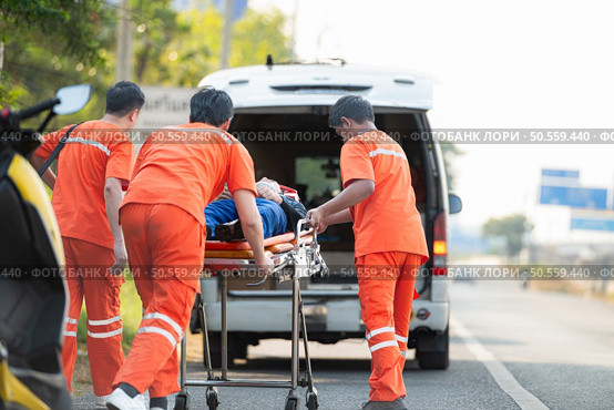 The paramedic  is assisting an injured man in an emergency situation on the road. Стоковое фото, агентство Ingram Publishing / Фотобанк Лори