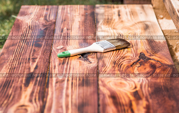 The procedure for protecting and coating wooden boards. The texture of wood treated with stain. Close-up of stain and brush. Стоковое фото, фотограф Photojuli / Фотобанк Лори