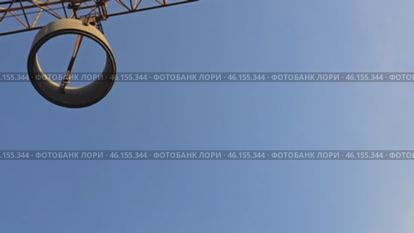 The ring is moved to the storage warehouse, the cargo hangs on strong cables while the crane carefully moves it over the territory of the construction site. Стоковое видео, видеограф Скрипачев Антон / Фотобанк Лори