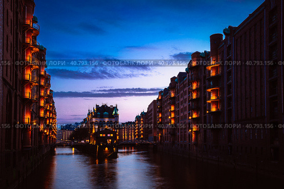 The Warehouse District - Speicherstadt in twilight. Tourism landmark of Hamburg. View of Wandrahmsfleet in light of lantern lamp. Port of Hamburg within the HafenCity quarter (2018 год). Стоковое фото, фотограф Igor Tichonow / Фотобанк Лори