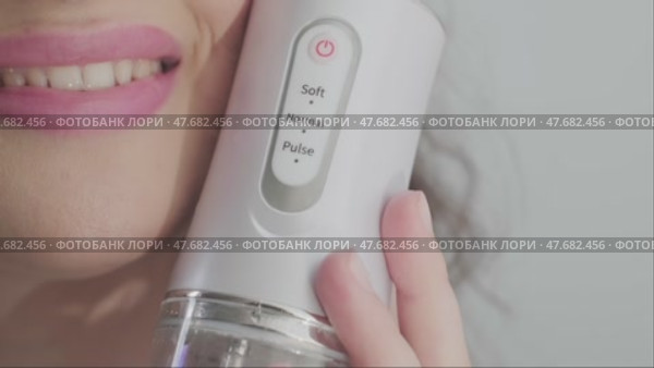 The woman shows her dazzling smile, achieved through regular use of a dental irrigator. Easy and effective dental care. Стоковое видео, видеограф Svetlana Golovco / Фотобанк Лори