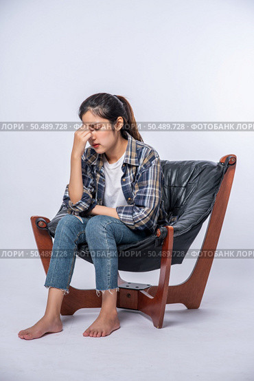 The woman was sick, sat on a chair, and touched her head with her hand. Стоковое фото, агентство Ingram Publishing / Фотобанк Лори