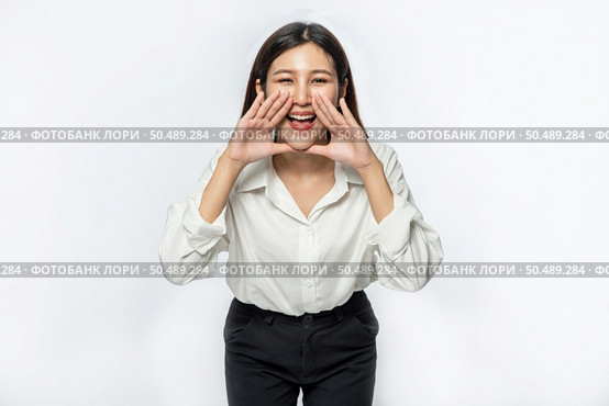 The woman wore a white shirt and black trousers and make a hand shout of joy. Стоковое фото, агентство Ingram Publishing / Фотобанк Лори