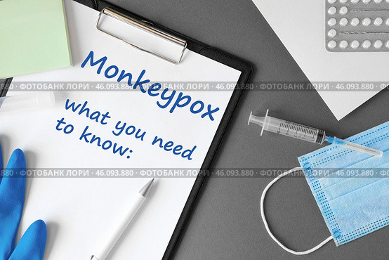 The word Monkeypox what you need to know on Gray modern doctor desk table background. Mask, notepad, syringe and supplies. Monkey pox spreading. Medicine and healthcare, medical education. Top view. Стоковое фото, фотограф Марина Демидюк / Фотобанк Лори