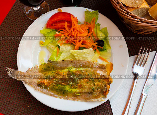 There is plate with fried solea flatfish and salad of fresh veg on wooden table. Стоковое фото, фотограф Яков Филимонов / Фотобанк Лори