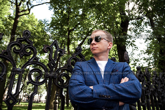 Thinking Man in a Blue Blazer Rests at the Wrought Iron Fence in Central Park. Стоковое фото, фотограф Aleksandr Golubev / Фотобанк Лори