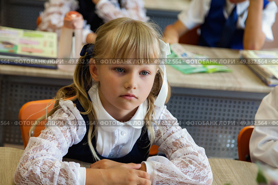 Thoughtful First-Grader in a Classroom Setting Engages in Learning With Focus and Curiosity. Стоковое фото, фотограф Aleksandr Golubev / Фотобанк Лори