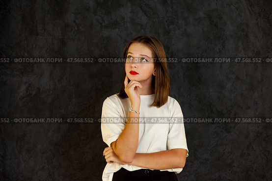 Thoughtful Teenage Girl Pondering Ideas Against a Dark Background With a Sense of Introspection. Стоковое фото, фотограф Aleksandr Golubev / Фотобанк Лори