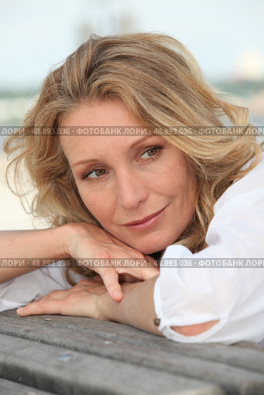 Thoughtful woman resting her head on the back of a bench. Стоковое фото, агентство Ingram Publishing / Фотобанк Лори