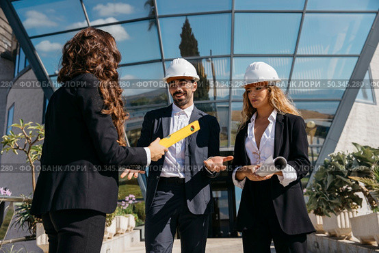 three architects talking front glass buidling. Стоковое фото, агентство Ingram Publishing / Фотобанк Лори