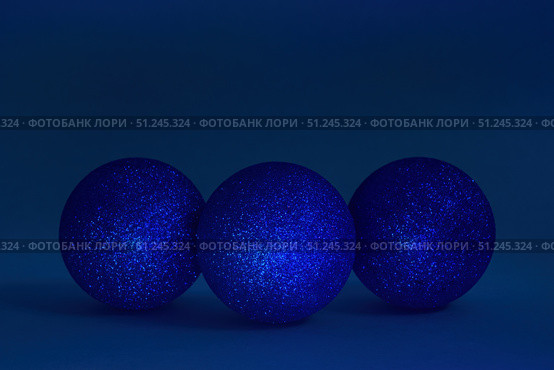 Three glitter christmas balls on dark blue background. Copy space, selective focus. Стоковое фото, фотограф Зарифа Арсланова / Фотобанк Лори