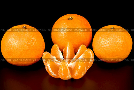 Three whole tangerines and one cleared on a black background. Стоковое фото, фотограф Artem Sobov / Фотобанк Лори