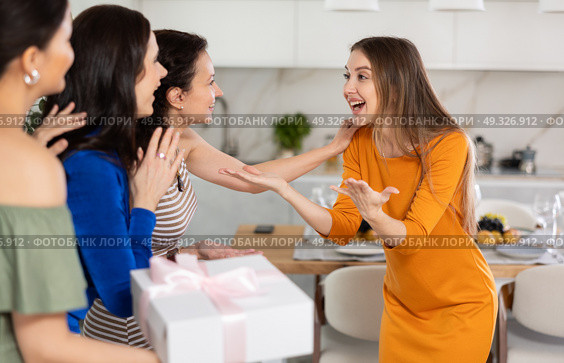 Three women have arrived for birthday celebration and presenting gift to birthday woman. Стоковое фото, фотограф Яков Филимонов / Фотобанк Лори