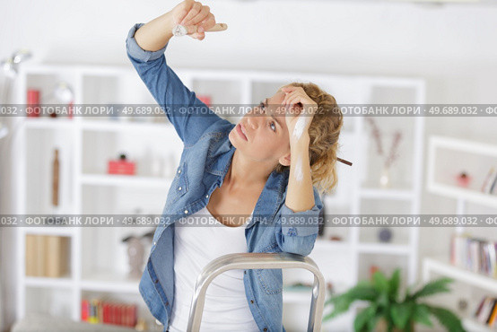 tired woman painting the ceiling overhead. Стоковое фото, агентство Ingram Publishing / Фотобанк Лори